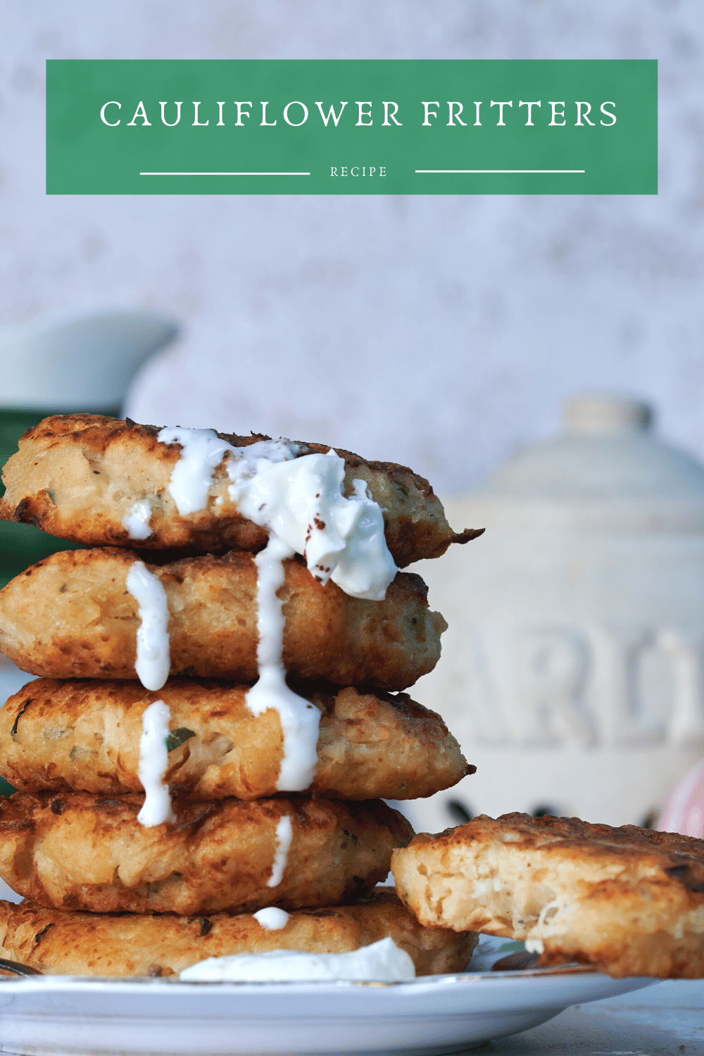 Pinable image for Turkish Cauliflower Fritters. The picture shows a stack of cauliflower fritters, a garlic store and the top of a jug. The Turkish fritters are topped with a dollop of garlic yoghurt. Karnabahar Mücver  - Turkish cauliflower fritters. Exploring The Turkish Kitchen'. 