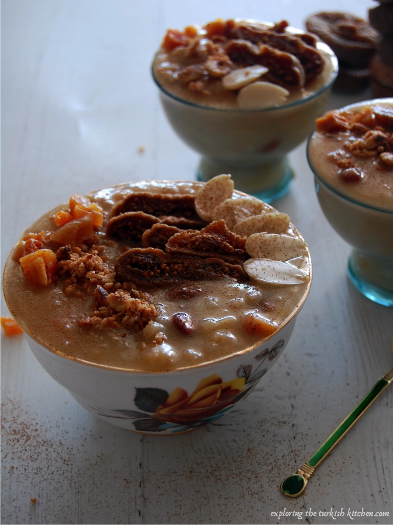 Three bowls of Noah's pudding or ashure. A traditionallt shared pudding. Dusted cinnamon falls on the wooden table and above the dried fruşt and nuts served on the pudding bowls. 